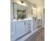 Stylish bathroom features double sink vanity with black hardware, a soaking tub and gray tile shower at 964 Double Helix Rd, Apex, NC 27523