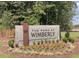 Landscaped community sign for The Park at Wimberly, surrounded by lush greenery and seasonal flowers at 964 Double Helix Rd, Apex, NC 27523