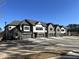 Row of townhomes with neutral exteriors, stone accents, attached garages, and well-maintained landscaping at 964 Double Helix Rd, Apex, NC 27523