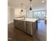 Open-concept kitchen with white countertops, stainless steel appliances, a large island, and hardwood floors at 964 Double Helix Rd, Apex, NC 27523