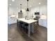 Modern kitchen featuring white cabinets, stainless steel appliances, a large island, and hardwood floors at 964 Double Helix Rd, Apex, NC 27523