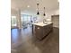 Open concept kitchen with a large island and pendant lighting overlooking the living area with lots of natural light at 964 Double Helix Rd, Apex, NC 27523