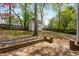 Backyard showcasing mature trees, a storage shed, a privacy fence, and a brick patio at 1012 Trail Stream Way, Knightdale, NC 27545