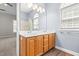 Bright bathroom with double vanity, window, framed mirror, and wood-look floors at 1012 Trail Stream Way, Knightdale, NC 27545
