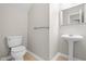 Half bathroom with a pedestal sink, mirror, and modern toilet at 1012 Trail Stream Way, Knightdale, NC 27545