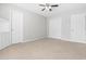 Bedroom with carpeted floors, ceiling fan, three doors with white trim, and neutral paint at 1012 Trail Stream Way, Knightdale, NC 27545