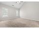 A bright and airy bedroom with a high ceiling, neutral walls, carpet, and two windows at 1012 Trail Stream Way, Knightdale, NC 27545