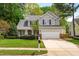 Charming two-story home with gray siding, black shutters, well-manicured lawn and mature trees at 1012 Trail Stream Way, Knightdale, NC 27545