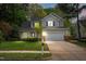 Dusk view of charming two-story home with gray siding, black shutters, well-manicured lawn, trees at 1012 Trail Stream Way, Knightdale, NC 27545