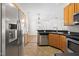 Open kitchen with stainless steel refrigerator, black countertops, and wooden cabinets at 1012 Trail Stream Way, Knightdale, NC 27545