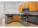 A well-equipped kitchen featuring stainless steel appliances, wood cabinets, and sleek countertops at 1012 Trail Stream Way, Knightdale, NC 27545
