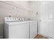 Laundry room with white front-load washer and dryer, wire rack, and wood-look floors at 1012 Trail Stream Way, Knightdale, NC 27545