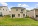 Manicured backyard featuring a well-maintained lawn and a neutral-colored two-story house with a sliding door at 104 Rosebud Ln, Durham, NC 27704