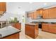 An open kitchen featuring wood cabinets, stainless steel appliances, dark countertops, and a center island at 104 Rosebud Ln, Durham, NC 27704