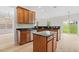 A kitchen with wood cabinets, stainless steel appliances, dark countertops, and a center island at 104 Rosebud Ln, Durham, NC 27704