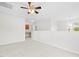 A carpeted room with white walls, a ceiling fan, and a view of other rooms at 104 Rosebud Ln, Durham, NC 27704