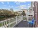 Balcony with white railing and blue chair overlooking lush green space and neighboring townhomes on a bright day at 10410 Sablewood Dr # 111, Raleigh, NC 27617