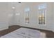 Bright living room featuring dark floors, wainscoting, and two large windows offering plenty of natural light at 10410 Sablewood Dr # 111, Raleigh, NC 27617