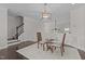 Inviting living room featuring a view of the staircase, modern pendant light, and a table with two chairs at 10410 Sablewood Dr # 111, Raleigh, NC 27617