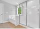 Bright bathroom featuring a tub, shower with glass enclosure, and neutral tile at 105 Scoville Rd, Garner, NC 27529
