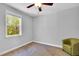 Cozy bedroom with a ceiling fan, neutral paint, large window with nature view, and chair at 105 Scoville Rd, Garner, NC 27529