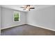 A simple bedroom offers neutral walls, carpet flooring, and a window view at 105 Scoville Rd, Garner, NC 27529