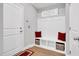 Welcoming mudroom features a bench with storage, decorative pillows, and 