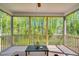 Inviting screened porch with wooden floors, natural light, and an excellent view of the surrounding trees at 105 Scoville Rd, Garner, NC 27529