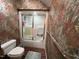 Bathroom with a toilet and shower stall featuring patterned wallpaper and brick floors at 106 Orchard Rd, Henderson, NC 27536