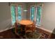 Cozy dining area featuring natural light from two windows and a round wooden table with four chairs at 106 Orchard Rd, Henderson, NC 27536