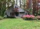 Charming contemporary home with a gray exterior, landscaped yard, and mature trees at 106 Orchard Rd, Henderson, NC 27536