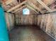 Unfinished interior space with wood walls, tiled floors, peaked roof and window for natural light at 106 Orchard Rd, Henderson, NC 27536