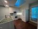 Well-lit kitchen featuring white appliances, a skylight, and a convenient door to the outside deck at 106 Orchard Rd, Henderson, NC 27536