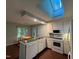 Bright kitchen area featuring a view of the dining space, a skylight, and essential appliances at 106 Orchard Rd, Henderson, NC 27536
