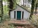 Outbuilding with wooden deck and a green door surrounded by trees at 106 Orchard Rd, Henderson, NC 27536