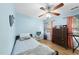 Well-lit bedroom featuring bright blue walls, hardwood floors, a ceiling fan, and a view of the window at 108 Ridgepath Way, Cary, NC 27511