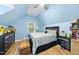 Cozy bedroom featuring bright blue walls, hardwood floors, a ceiling fan, and natural light at 108 Ridgepath Way, Cary, NC 27511