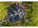 Aerial view of the house roof, deck, backyard, patio and surrounding landscape with mature trees at 108 Sierra Dr, Chapel Hill, NC 27514