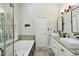 Beautiful bathroom featuring double sinks, a soaking tub, and a large arched window providing natural light at 108 Sierra Dr, Chapel Hill, NC 27514
