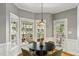Charming breakfast nook featuring large windows, a modern light fixture, and a round dining table at 108 Sierra Dr, Chapel Hill, NC 27514