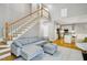 Inviting living room featuring a comfortable gray sectional sofa, staircase, and open view to the kitchen at 108 Sierra Dr, Chapel Hill, NC 27514