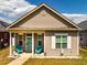 Cozy single-story home featuring a charming front porch with blue chairs and a quaint, well-maintained lawn at 110 Plott Hound Dr, Clayton, NC 27520