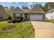 Charming single-story home features a two-car garage, stone accents, and beautifully landscaped front yard at 112 Pink Dogwood Ln, Mebane, NC 27302