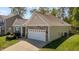 Angle view of a single-story home with a two-car garage and well-maintained lawn at 112 Pink Dogwood Ln, Mebane, NC 27302