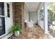 Inviting front porch with stone accents, seating, and decorative ferns welcomes you home at 1120 Scholastic Cir, Durham, NC 27713