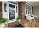 Inviting front porch with stone flooring and white wicker furniture, perfect for relaxing at 1120 Scholastic Cir, Durham, NC 27713