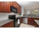 Well-lit kitchen featuring granite counters, tile backsplash and stainless-steel appliances at 1120 Scholastic Cir, Durham, NC 27713
