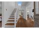 Bright entryway featuring hardwood floors, white walls, and an open staircase leading to the upper level at 116 W Front St, Oxford, NC 27565