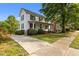 Charming two-story home with white siding, black shutters, a cozy front porch, and landscaped front yard at 116 W Front St, Oxford, NC 27565