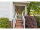 Inviting front porch with brick steps, white railings, and lush landscaping at 116 W Front St, Oxford, NC 27565